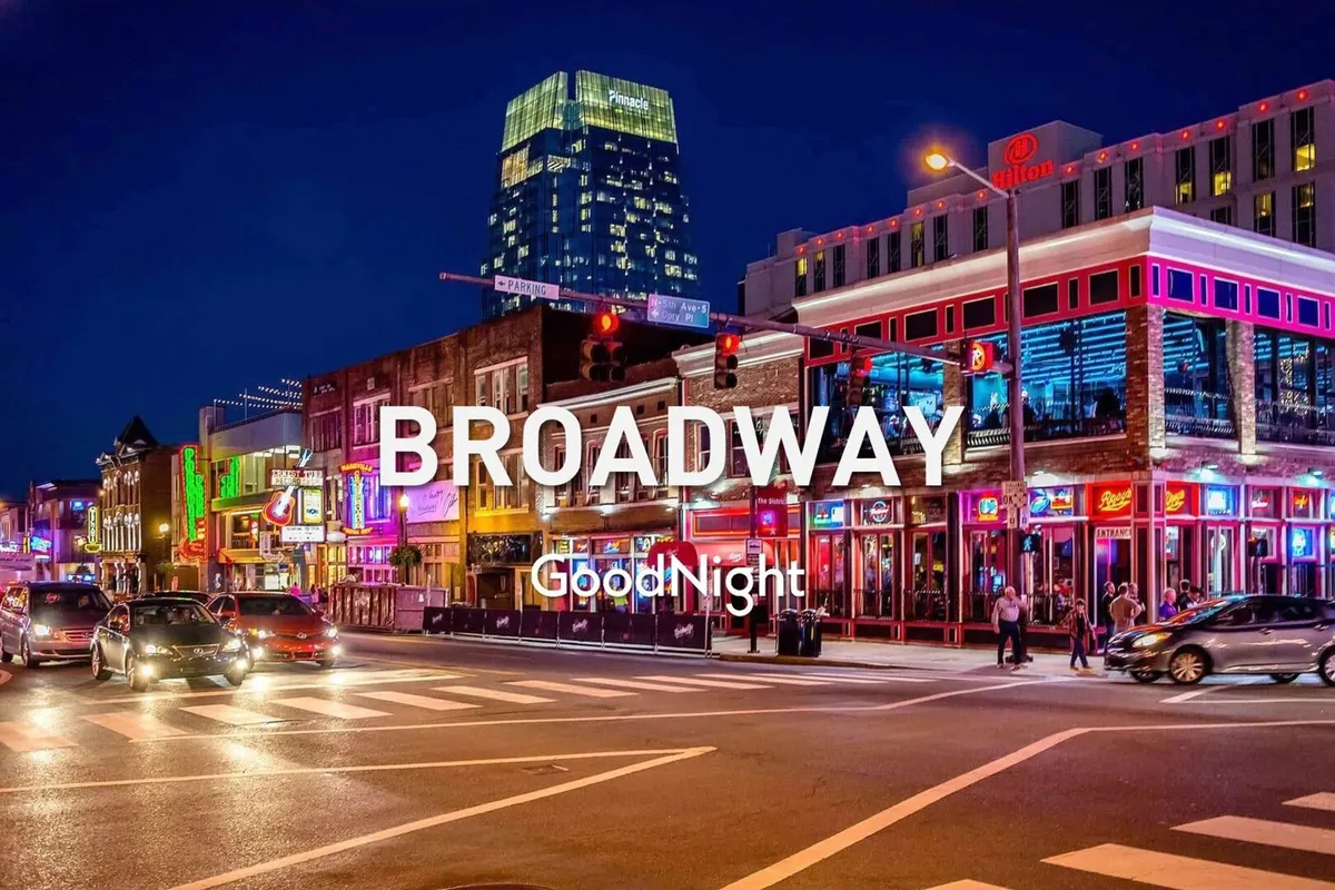 A vibrant Nashville nightlife scene with neon lights illuminating a busy street, bustling crowds, and high-rise buildings in the background. The energetic atmosphere suggests a lively downtown area known for live music, dining, and entertainment.